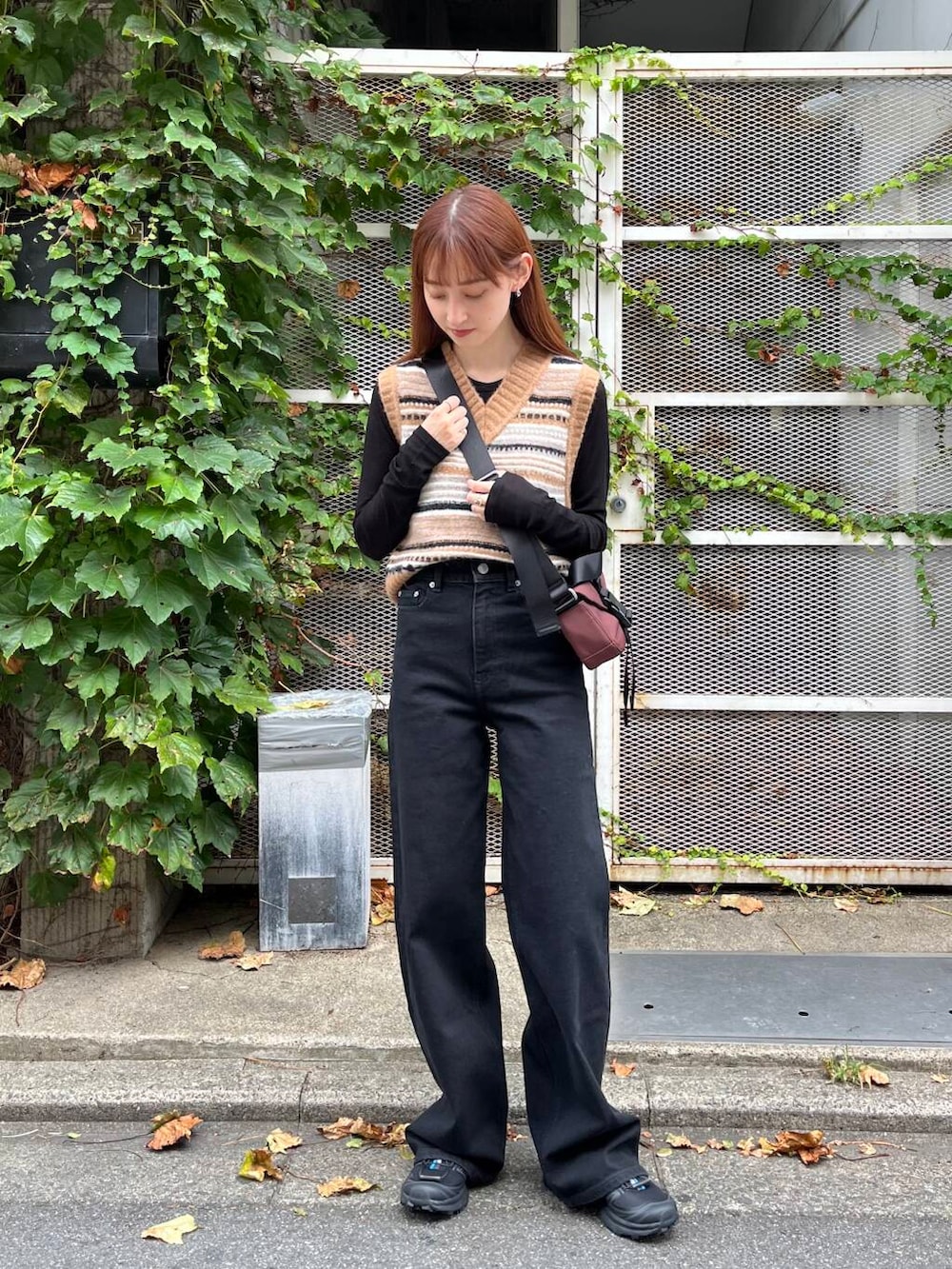 ブラック系のTシャツ/カットソー、ブラック系のスニーカー、ブラウン系のベストを着用したレディースの夏コーディネートの5枚目の写真