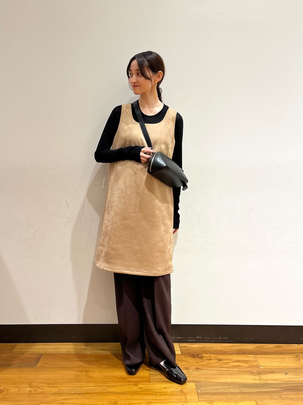 ベージュ系のワンピース、ブラック系のTシャツ/カットソー、ブラック系のローファーを着用したレディースの秋コーディネートの2枚目の写真