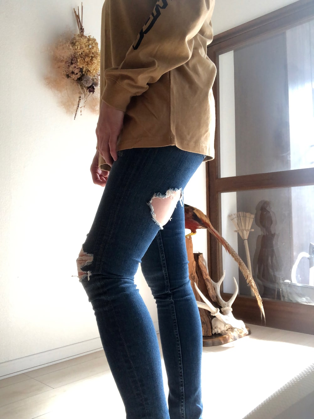 ブルー系のデニムパンツ、ベージュ系のTシャツ/カットソーを着用したレディースの秋コーディネートの2枚目の写真