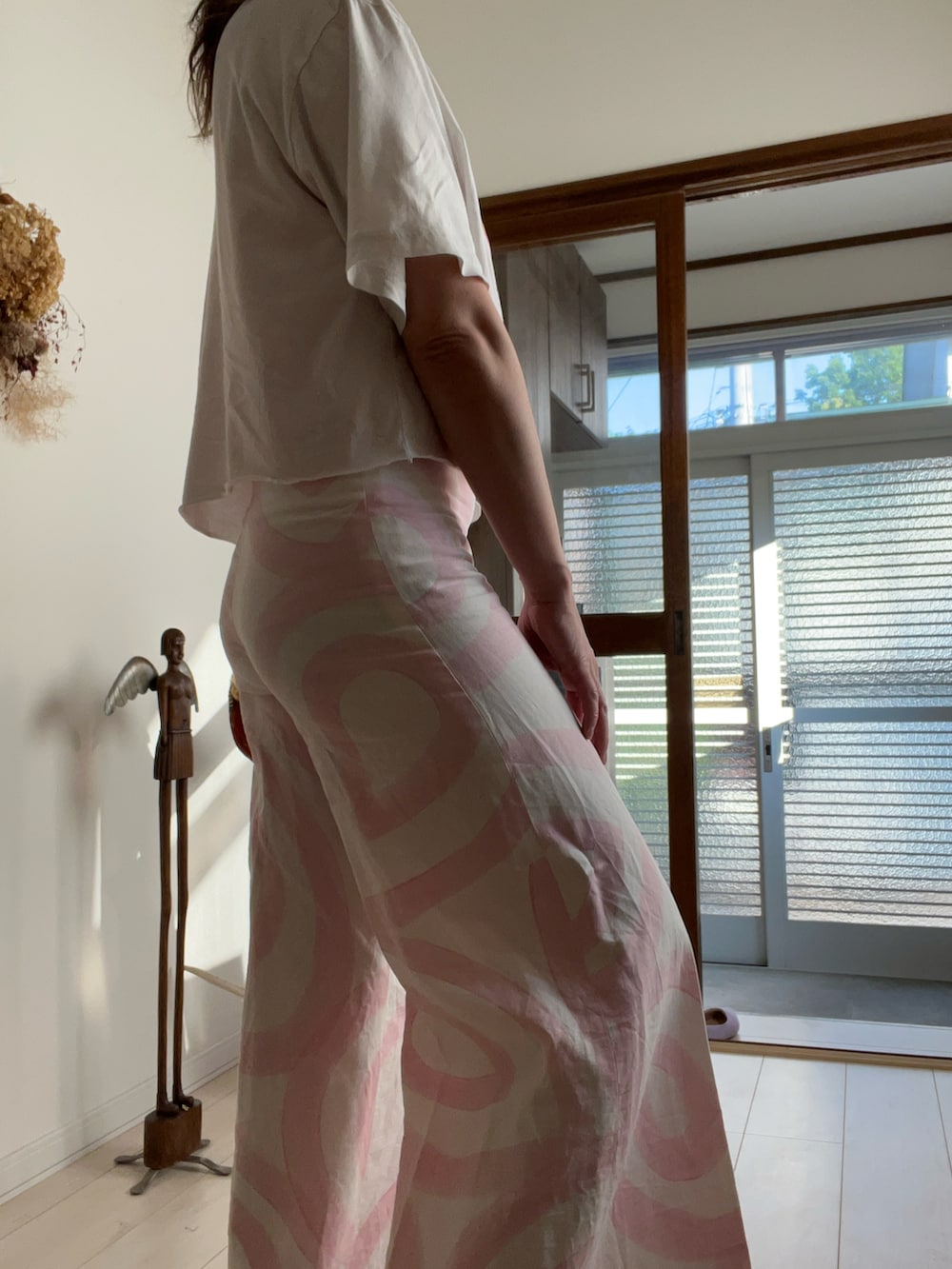 ホワイト系のTシャツ/カットソー、ホワイト系のパンツ、レッド系のスポーツブラを着用したレディースの夏コーディネートの2枚目の写真