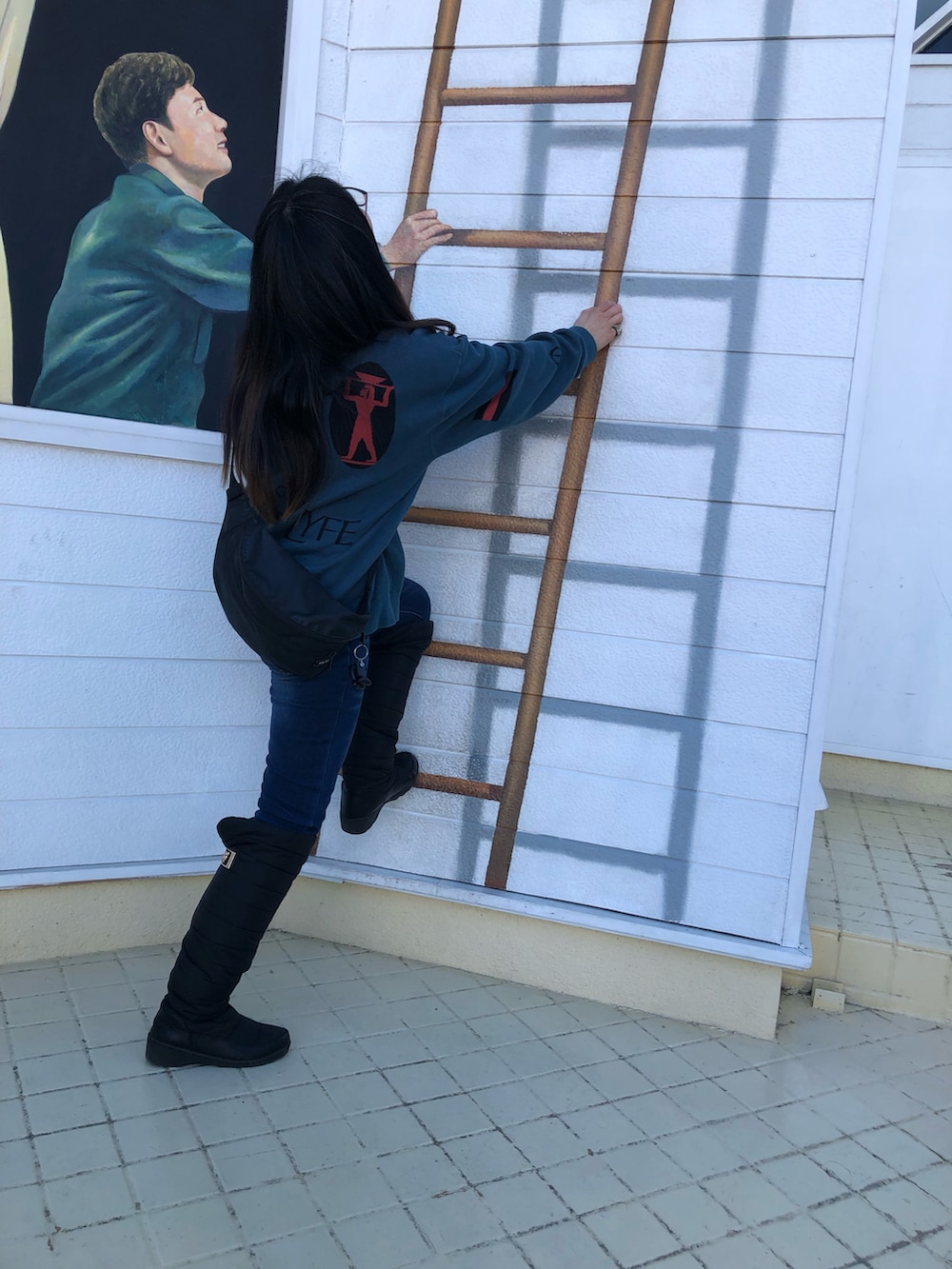 ブラック系のブーツ、グリーン系のニット/セーター、ブラック系のボディバッグ/ウエストポーチを着用したレディースの春コーディネートの2枚目の写真