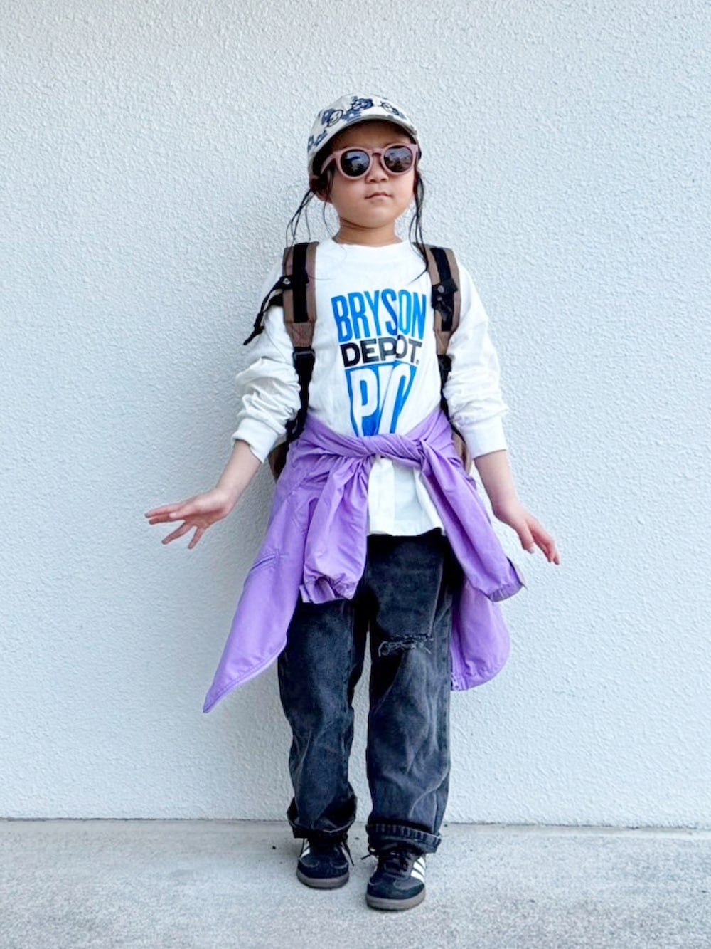 ブラウン系のバックパック/リュック、ホワイト系のTシャツ/カットソー、パープル系のその他アウターを着用したキッズの春コーディネートの2枚目の写真