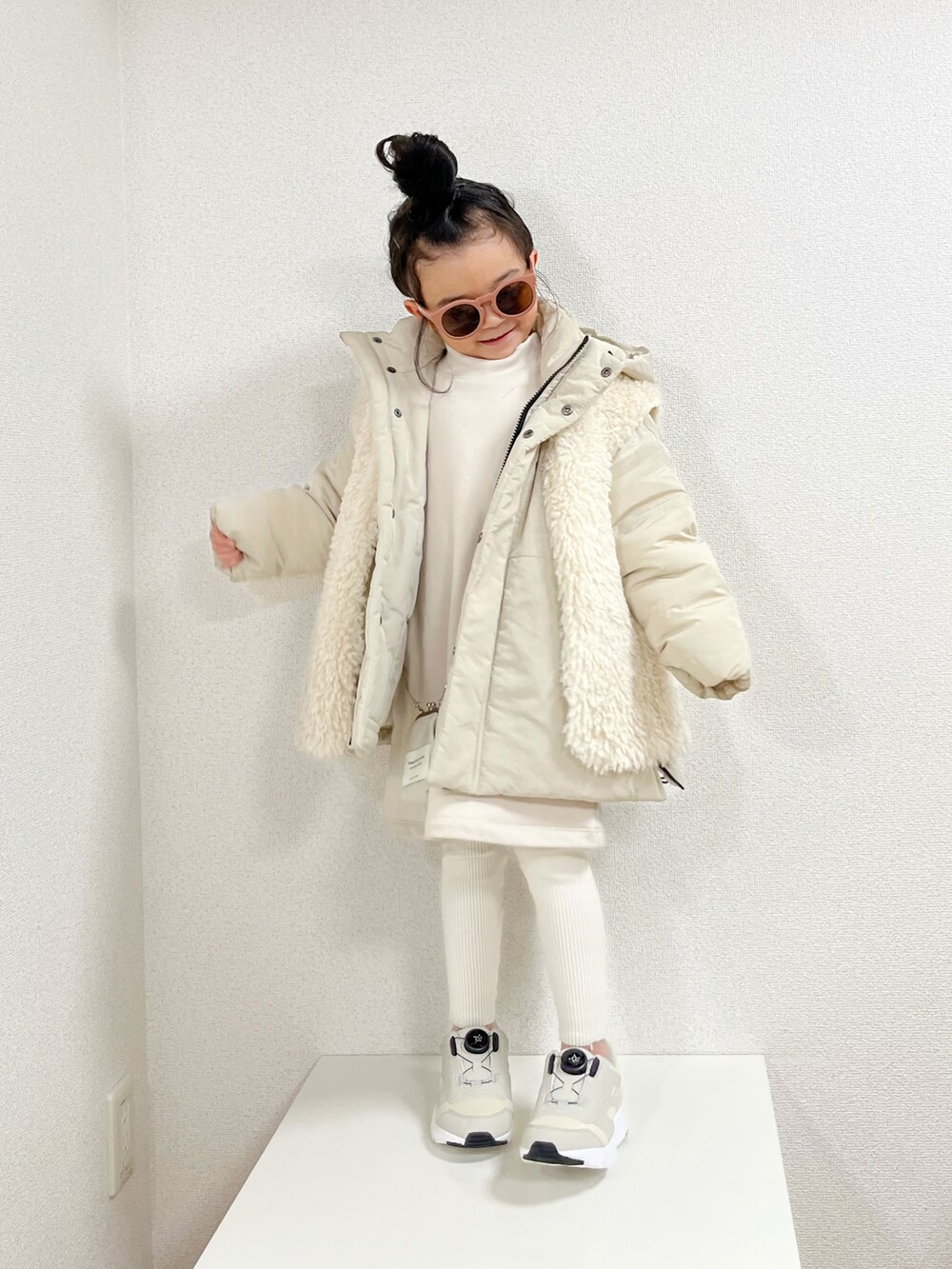 ホワイト系のダウンジャケット/コート、ホワイト系のベスト、ベージュ系のスニーカーを着用したキッズの冬コーディネートの2枚目の写真