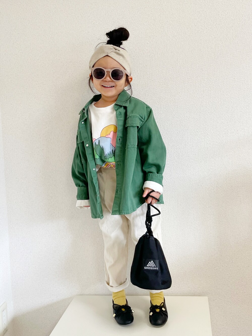 ホワイト系のトップス、グリーン系のデニムジャケット、ブラック系のトートバッグを着用したキッズの春コーディネートの2枚目の写真