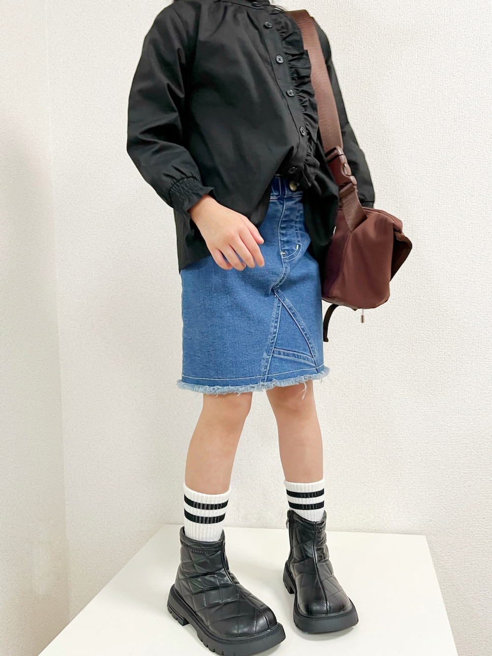 ブラウン系のショルダーバッグ、ブルー系のカバーオール、ブラック系のシャツ/ブラウスを着用したキッズの秋コーディネートの4枚目の写真