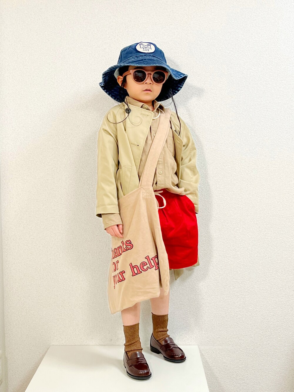 ベージュ系のトップス、ベージュ系のノーカラーコート、ベージュ系のトートバッグを着用したキッズの春コーディネートの2枚目の写真