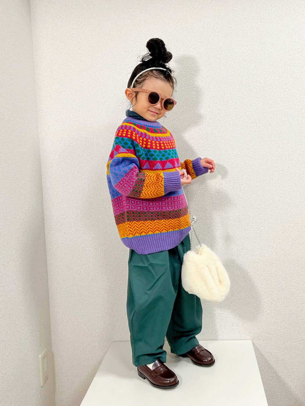 ホワイト系のニット/セーター、ホワイト系のボディバッグ/ウエストポーチ、グリーン系のその他パンツを着用したキッズの冬コーディネートの2枚目の写真