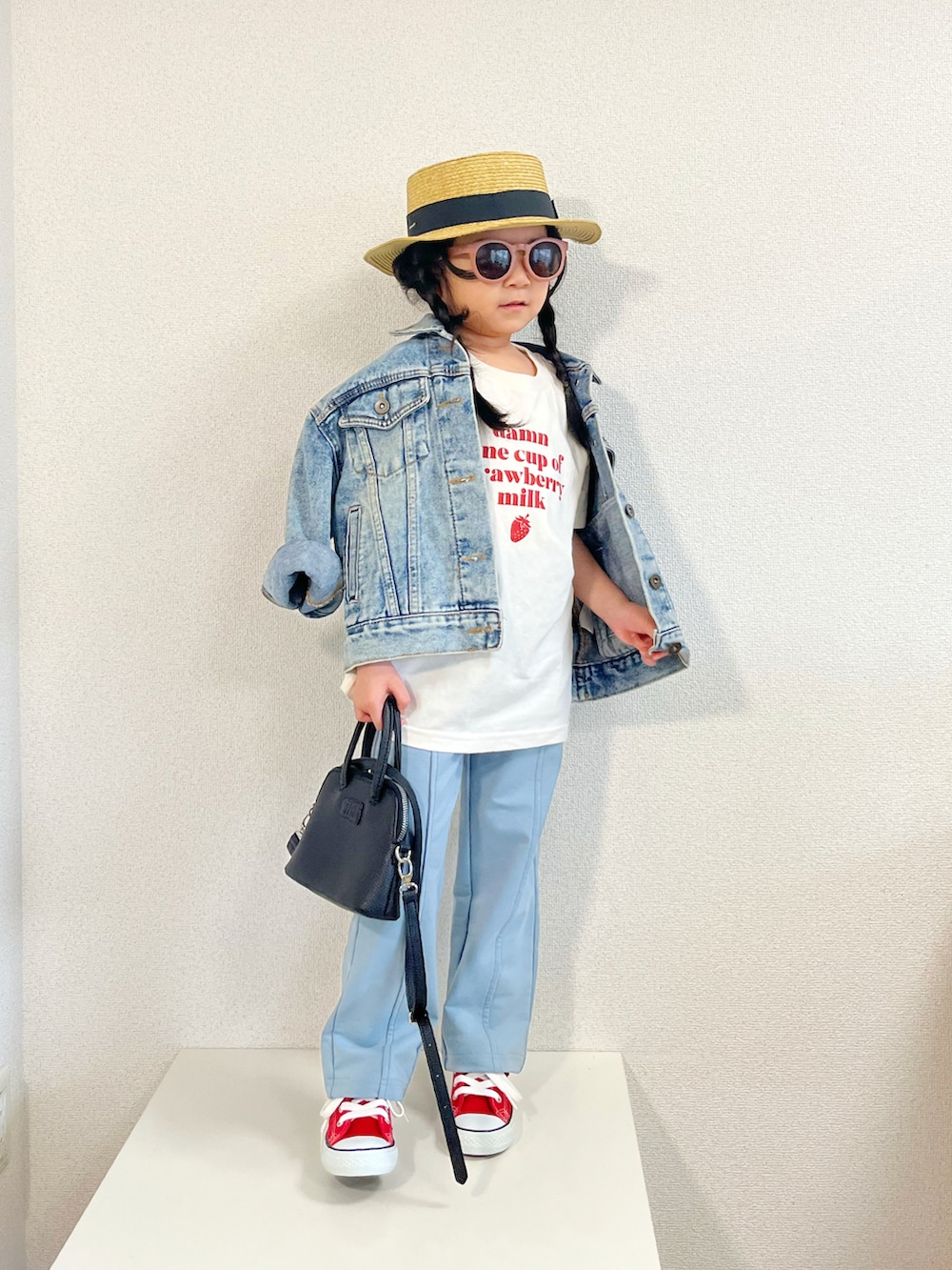 ブルー系のデニムジャケット、ブラック系のショルダーバッグ、ブルー系のその他パンツを着用したキッズの春コーディネートの2枚目の写真