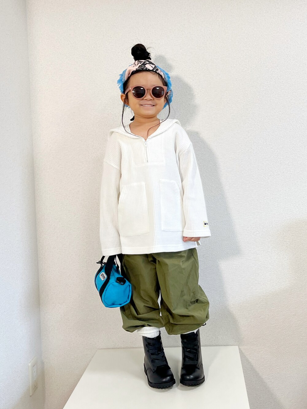 ホワイト系のTシャツ/カットソー、ブルー系のカバーオール、ブルー系のショルダーバッグを着用したキッズの冬コーディネートの2枚目の写真