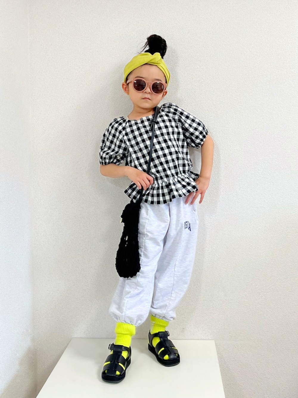 ブラック系のシャツ/ブラウス、ブラック系のショルダーバッグ、ホワイト系のパンツを着用したキッズの春コーディネートの2枚目の写真