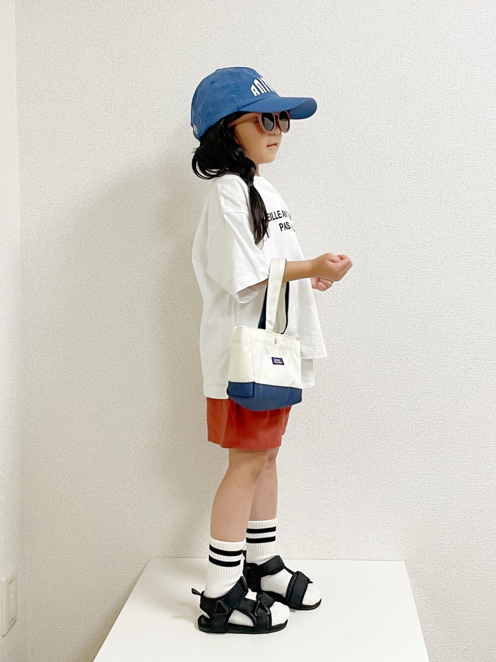 ホワイト系のTシャツ/カットソー、ホワイト系のタンクトップ、ベージュ系のトートバッグを着用したキッズの夏コーディネートの2枚目の写真