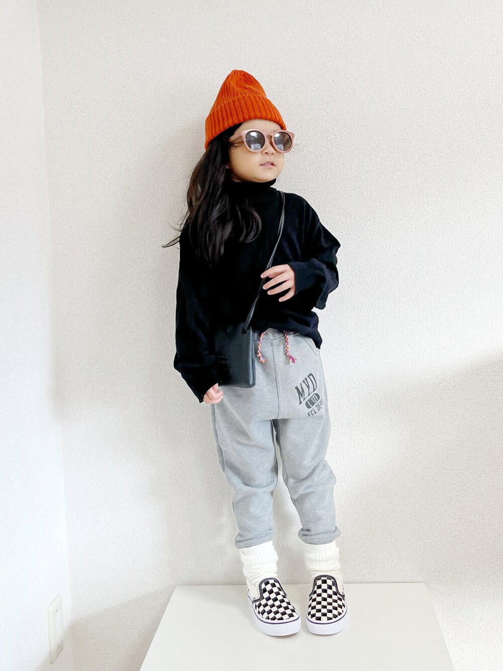 ブラック系のニット/セーター、ベージュ系のノーカラーコート、グレー系のスウェットパンツを着用したキッズの秋コーディネートの3枚目の写真