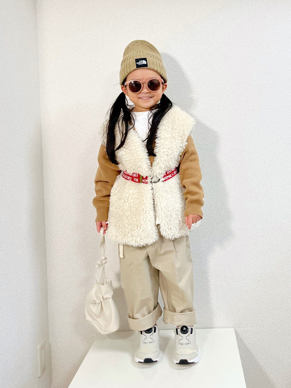 ブラウン系のカーディガン/ボレロ、ベージュ系のその他パンツ、ベージュ系のスニーカーを着用したキッズの冬コーディネートの2枚目の写真