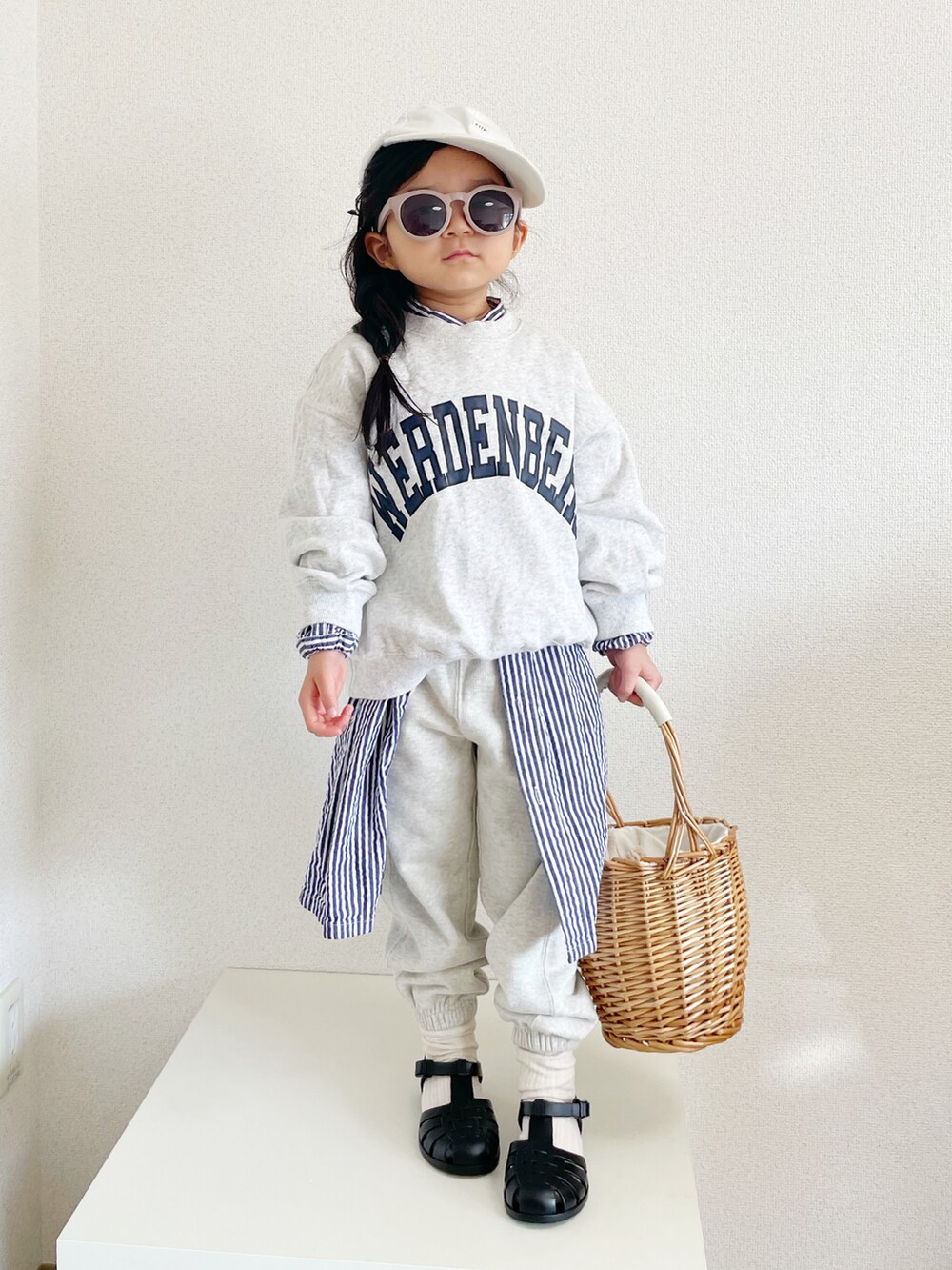 グレー系のスウェット、ブルー系のワンピース/ドレス、ベージュ系のかごバッグを着用したキッズの冬コーディネートの2枚目の写真