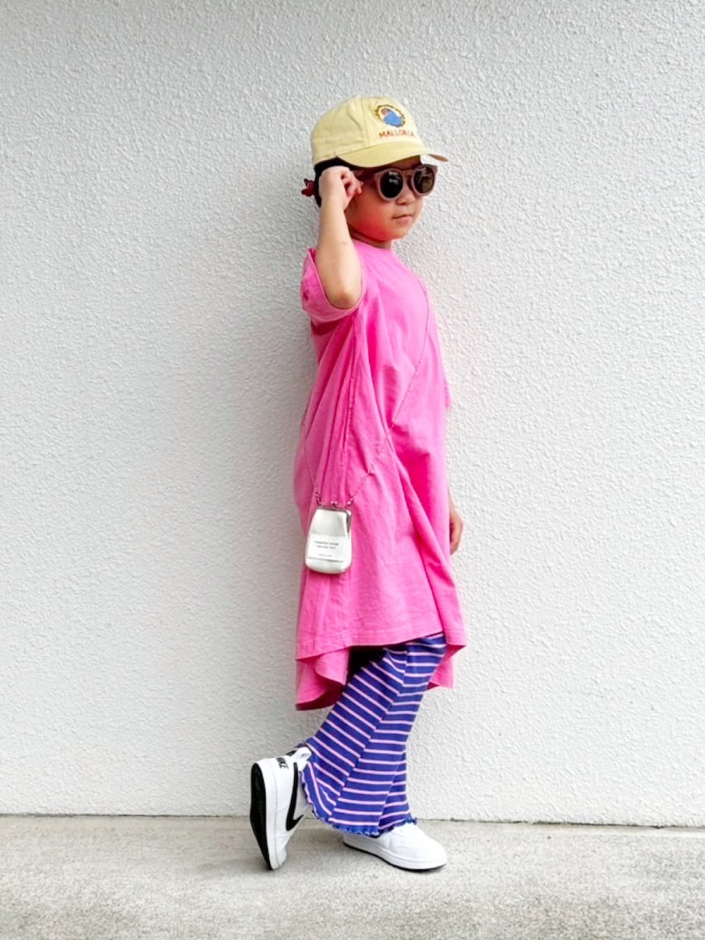 ピンク系のワンピース、ホワイト系のスニーカー、ブルー系のその他パンツを着用したキッズの夏コーディネートの2枚目の写真