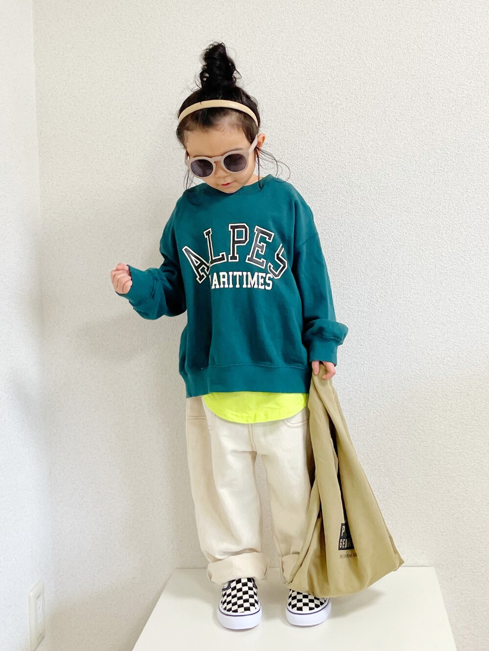 グリーン系のスウェット、イエロー系のタンクトップ、ベージュ系のエコバッグ/サブバッグを着用したキッズの春コーディネートの3枚目の写真