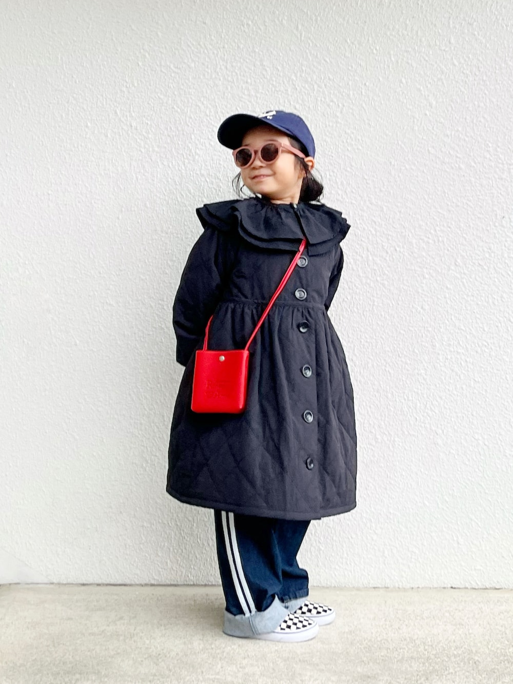 ブラック系のその他アウター、レッド系のバッグ、ブルー系のデニムパンツを着用したキッズの冬コーディネートの2枚目の写真