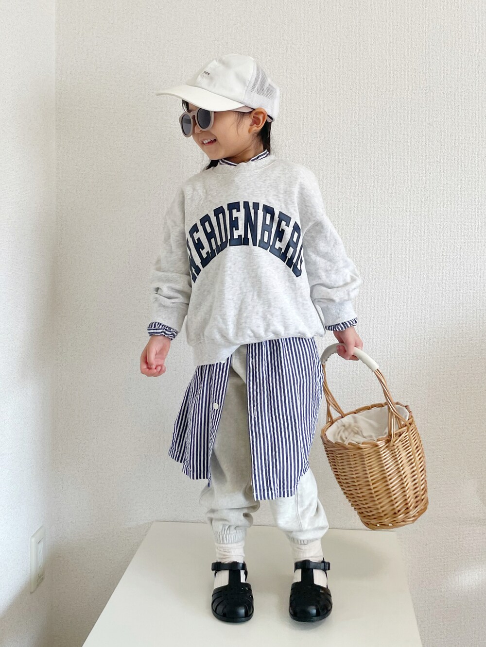 グレー系のスウェット、ブルー系のワンピース/ドレス、ベージュ系のかごバッグを着用したキッズの冬コーディネートの3枚目の写真