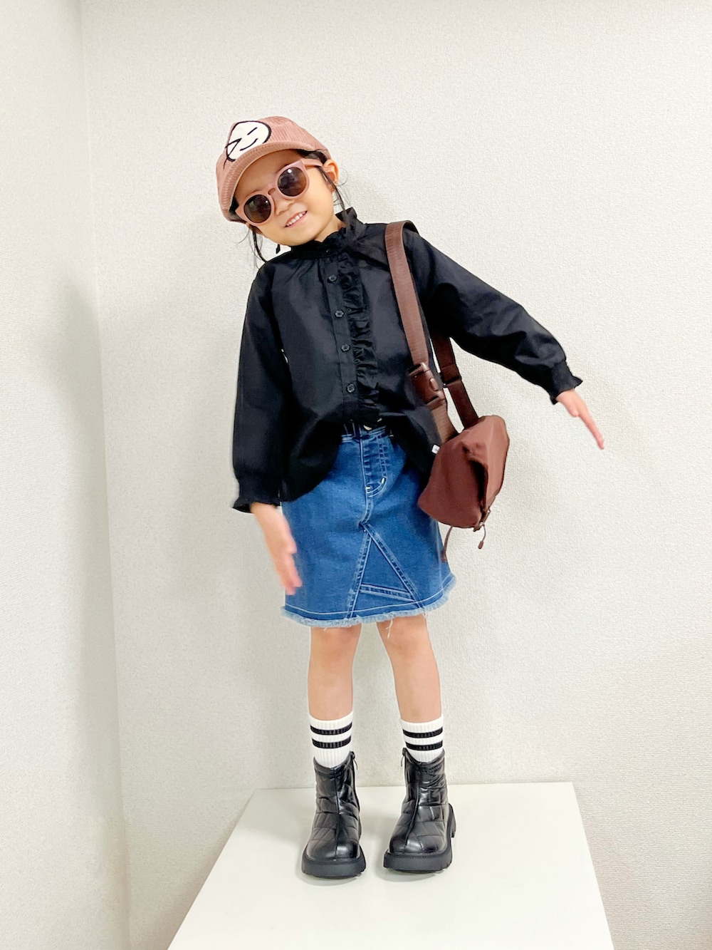 ブラウン系のショルダーバッグ、ブルー系のカバーオール、ブラック系のシャツ/ブラウスを着用したキッズの秋コーディネートの3枚目の写真