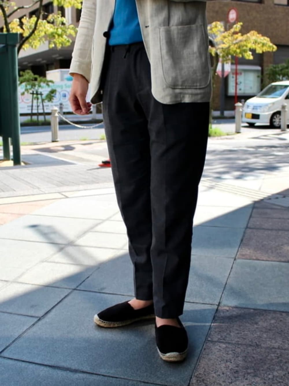 ブルー系のTシャツ/カットソー、ブラック系のスラックスを着用したメンズの春コーディネートの2枚目の写真