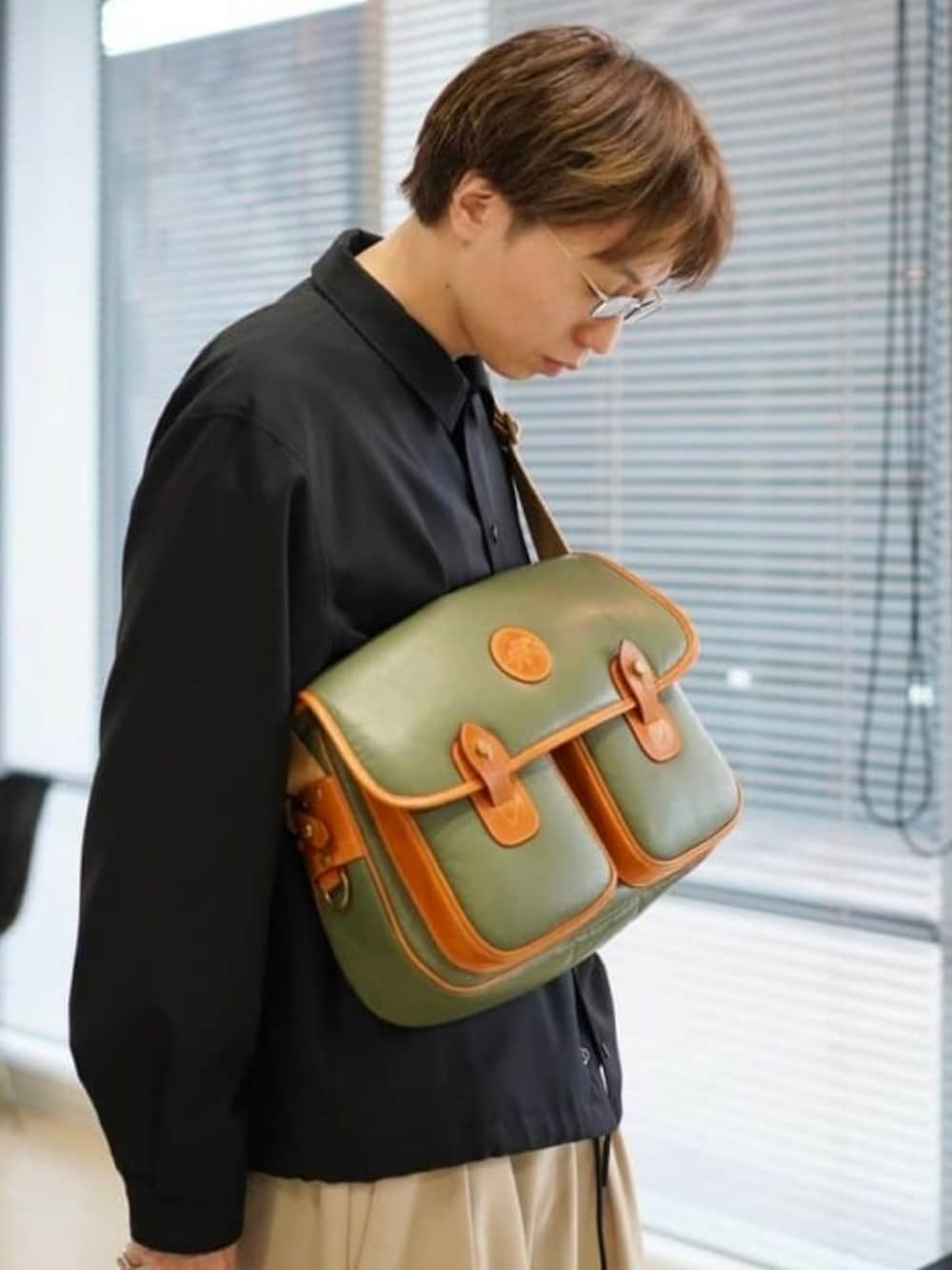 グリーン系のトートバッグ、ブラウン系のドレスシューズを着用したメンズの秋コーディネートの2枚目の写真
