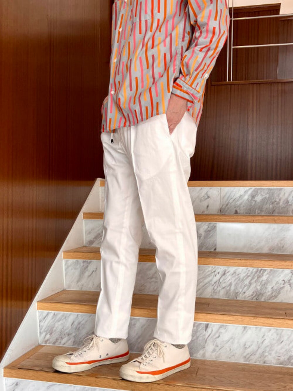 ホワイト系のスラックスを着用したメンズの春コーディネートの3枚目の写真