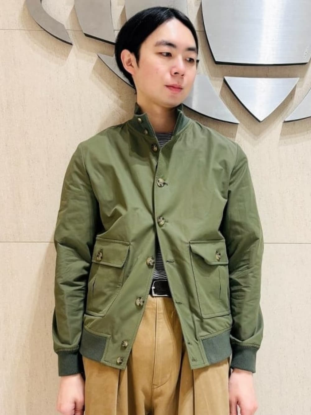 グリーン系のブルゾン、ブラック系のTシャツ/カットソーを着用したメンズの春コーディネートの2枚目の写真