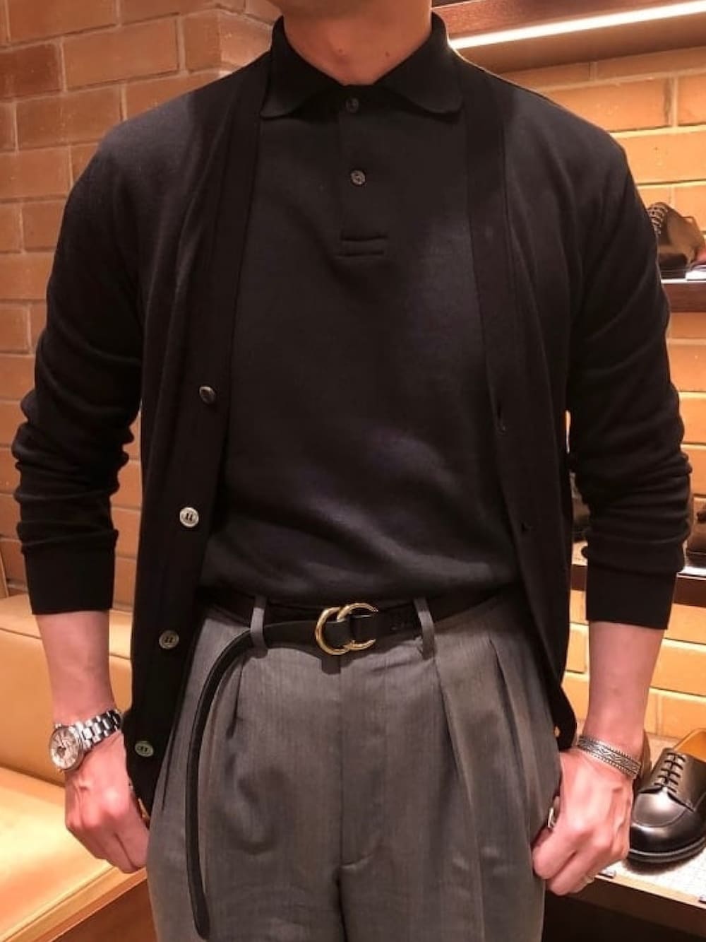 ブラック系のドレスシューズ、ブラック系のカーディガン/ボレロ、ブラック系のポロシャツを着用したメンズの夏コーディネートの2枚目の写真