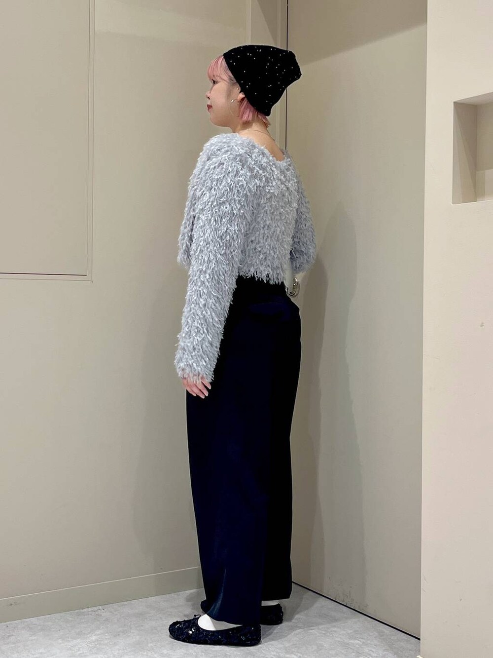 ブラック系のスラックス、ブラック系のバレエシューズ、シルバー系のショルダーバッグを着用したレディースの秋コーディネートの2枚目の写真