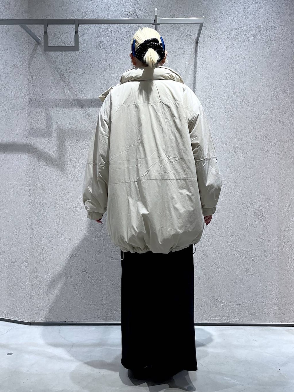 ブラック系のスカート、ホワイト系のブルゾン、レッド系のポロシャツを着用したレディースの秋コーディネートの3枚目の写真