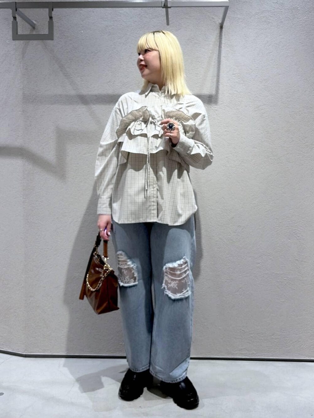 ブルー系のデニムパンツ、ブラウン系のショルダーバッグ、ブラック系のローファーを着用したレディースの冬コーディネートの2枚目の写真