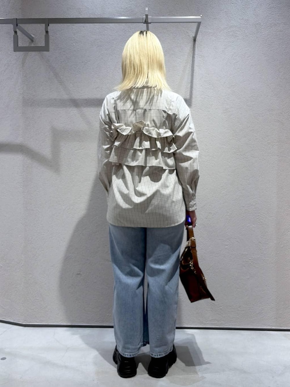 ブルー系のデニムパンツ、ブラウン系のショルダーバッグ、ブラック系のローファーを着用したレディースの冬コーディネートの4枚目の写真