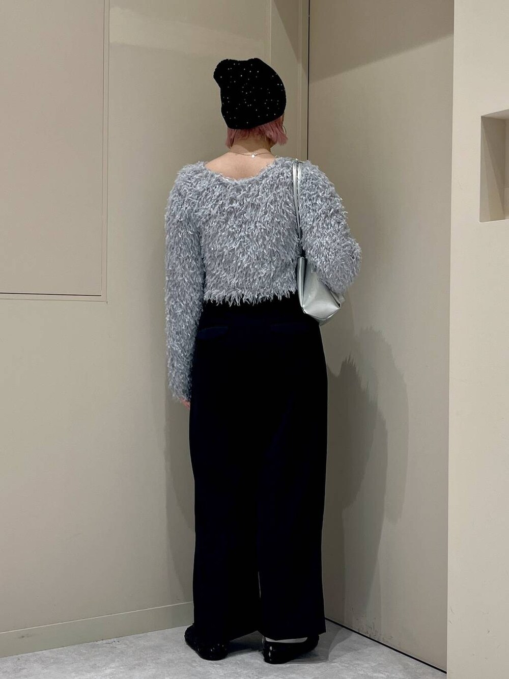 ブラック系のスラックス、ブラック系のバレエシューズ、シルバー系のショルダーバッグを着用したレディースの秋コーディネートの3枚目の写真