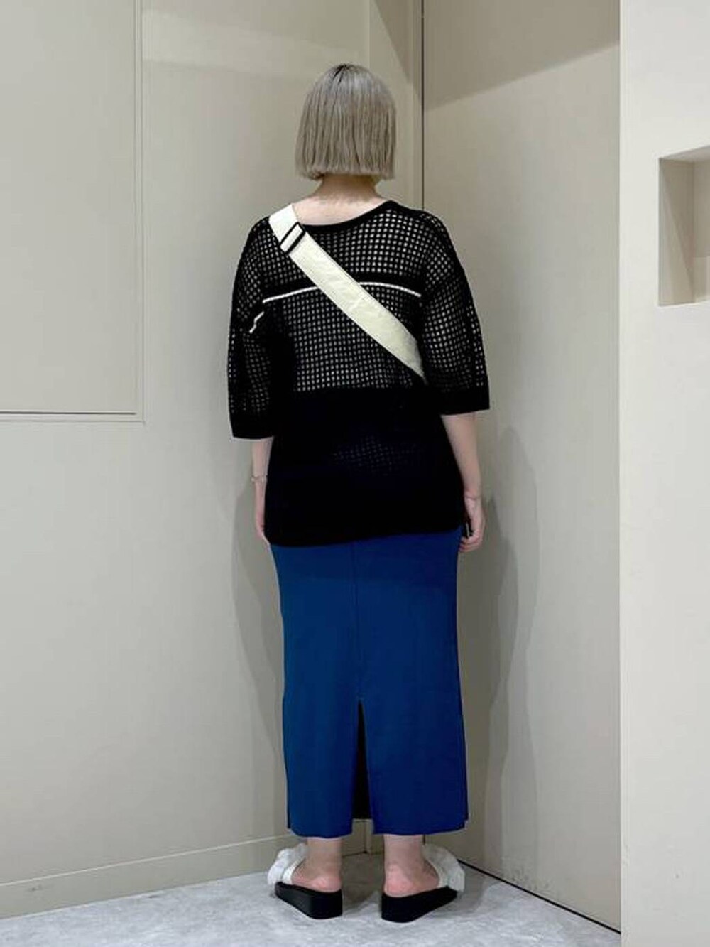 ブルー系のスカート、ホワイト系のサンダル、ブラック系のニット/セーターを着用したレディースの夏コーディネートの3枚目の写真