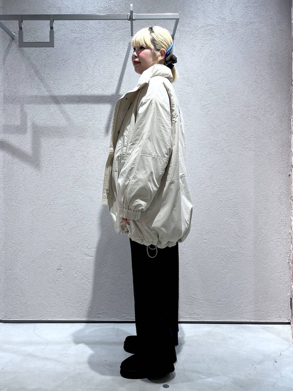 ブラック系のスカート、ホワイト系のブルゾン、レッド系のポロシャツを着用したレディースの秋コーディネートの2枚目の写真