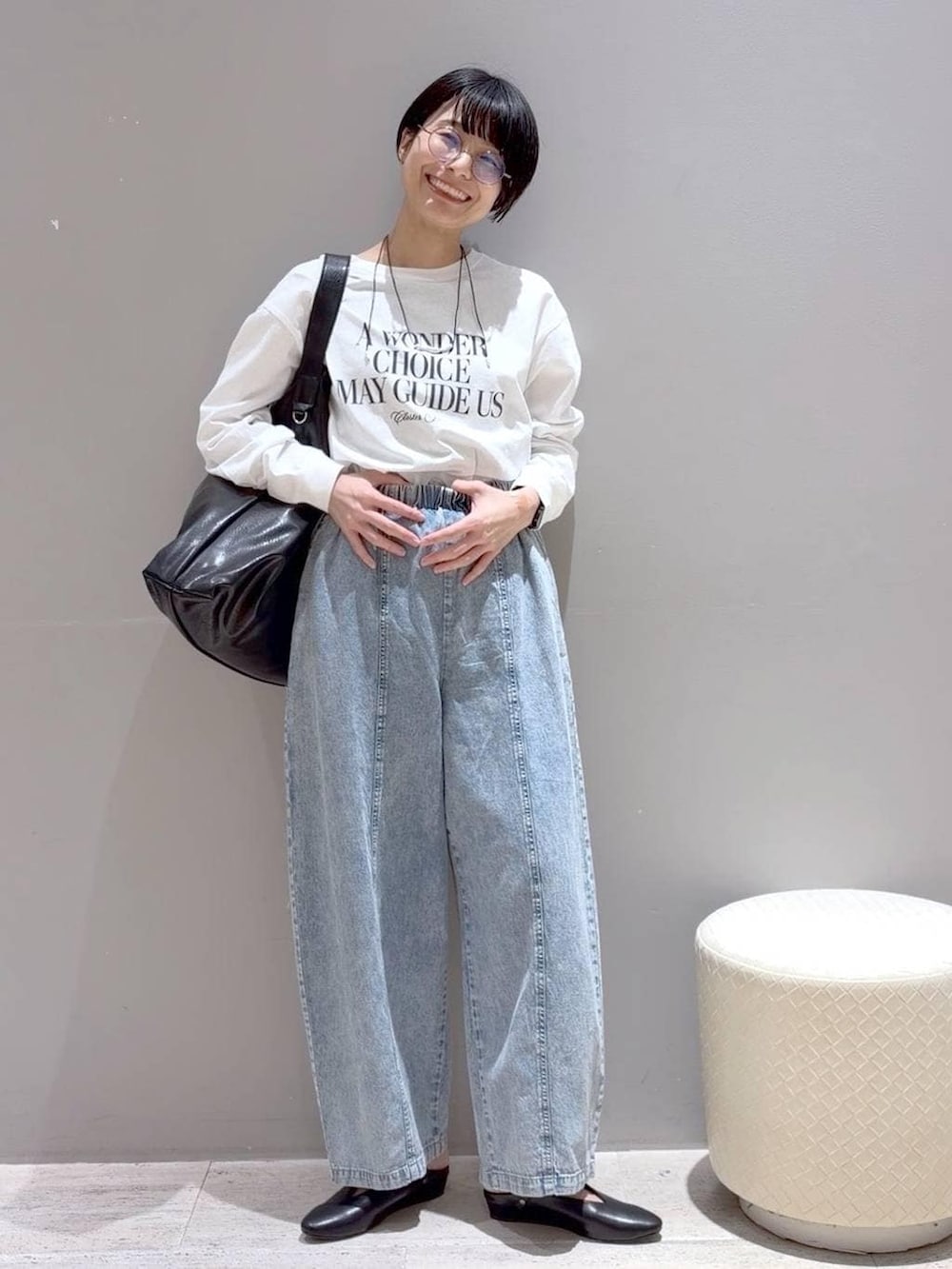 ブラック系のショルダーバッグ、ブラック系のパンプス、グレー系のベストを着用したレディースの春コーディネートの4枚目の写真