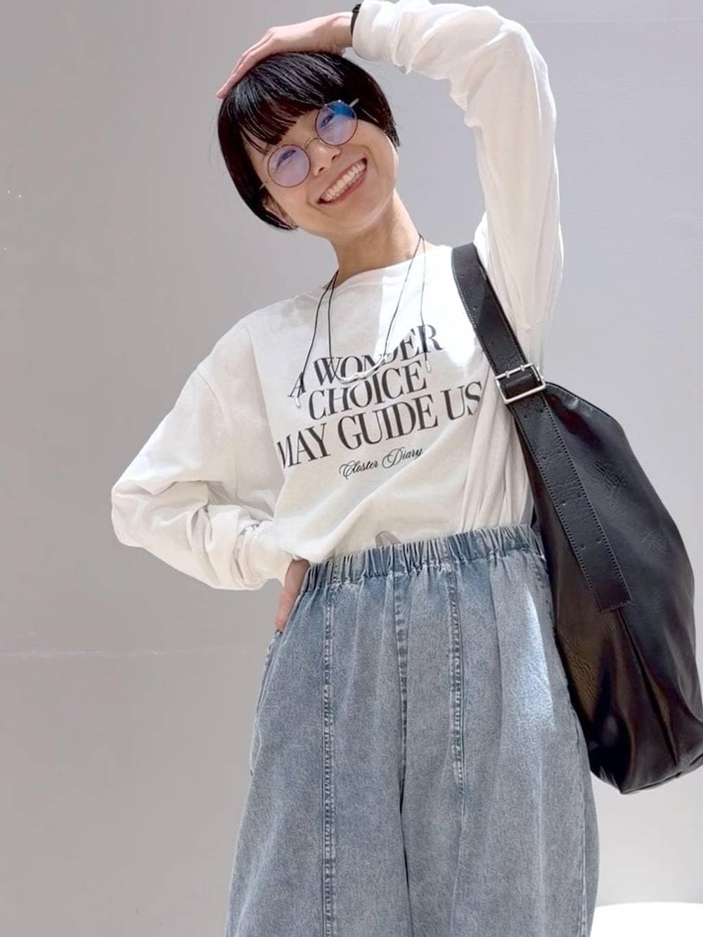 ブラック系のショルダーバッグ、ブラック系のパンプス、グレー系のベストを着用したレディースの春コーディネートの3枚目の写真