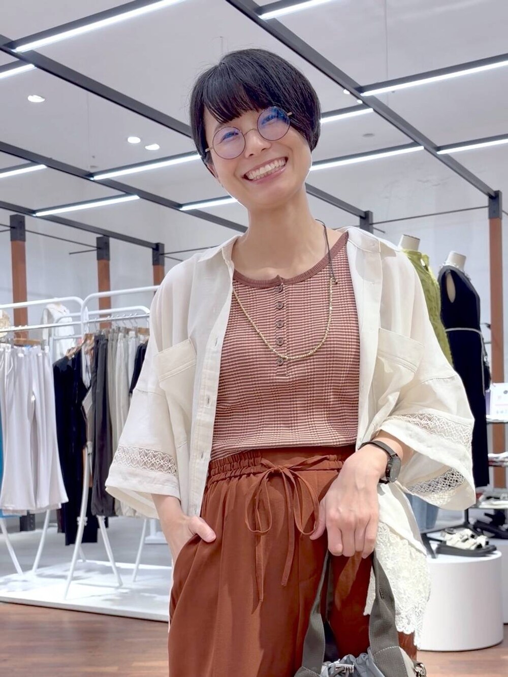 グリーン系のショルダーバッグ、ホワイト系のサンダル、ブラウン系のその他パンツを着用したレディースの夏コーディネートの2枚目の写真