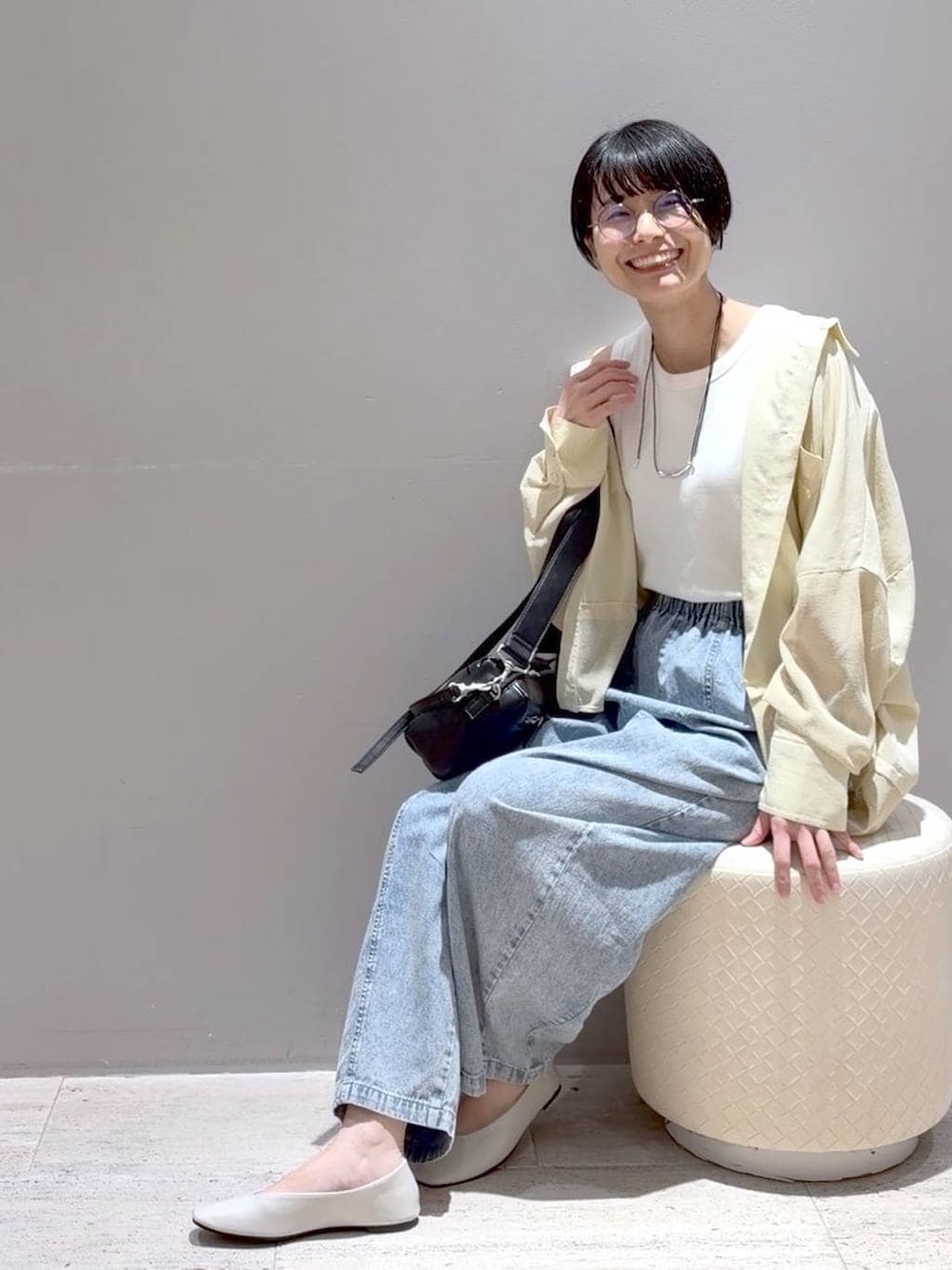 ホワイト系のパンプス、ホワイト系のタンクトップ、ブラック系のショルダーバッグを着用したレディースの春コーディネートの5枚目の写真