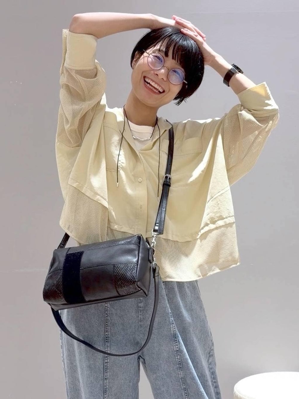 ホワイト系のパンプス、ホワイト系のタンクトップ、ブラック系のショルダーバッグを着用したレディースの春コーディネートの2枚目の写真