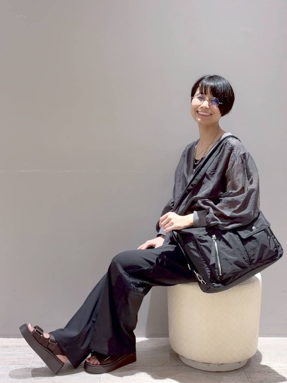 ブラック系のその他パンツ、ブラック系のショルダーバッグ、グレー系のシャツ/ブラウスを着用したレディースの夏コーディネートの2枚目の写真