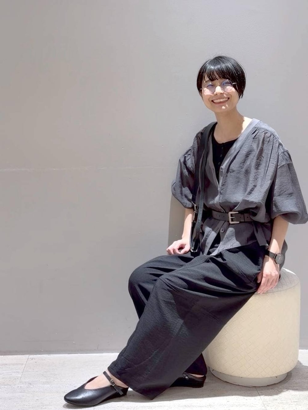 ブラック系のその他パンツ、グレー系のシャツ/ブラウス、ブラック系のショルダーバッグを着用したレディースの春コーディネートの2枚目の写真