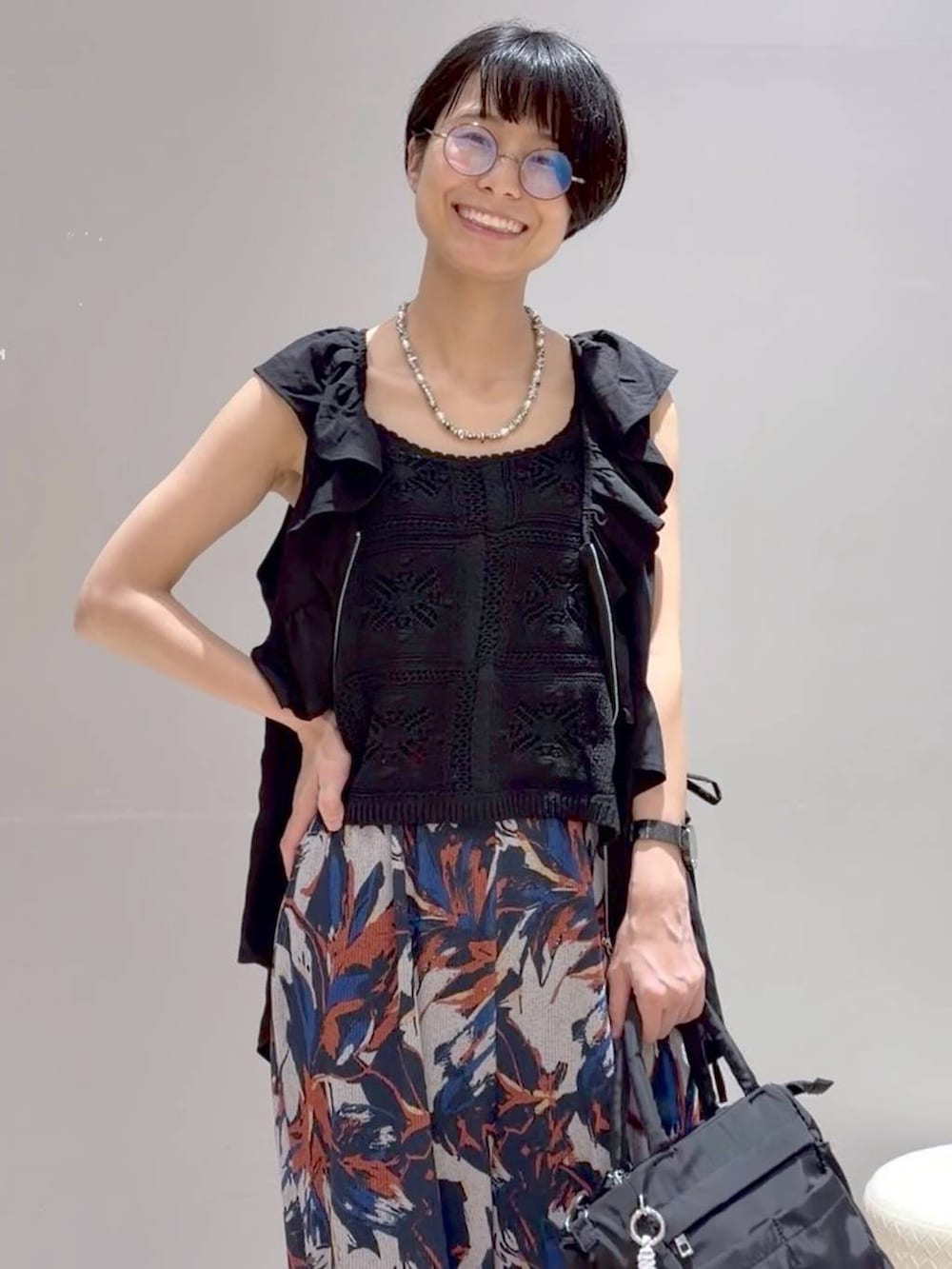 ブラック系のベスト、ホワイト系のその他パンツ、ブラック系のサンダルを着用したレディースの夏コーディネートの6枚目の写真