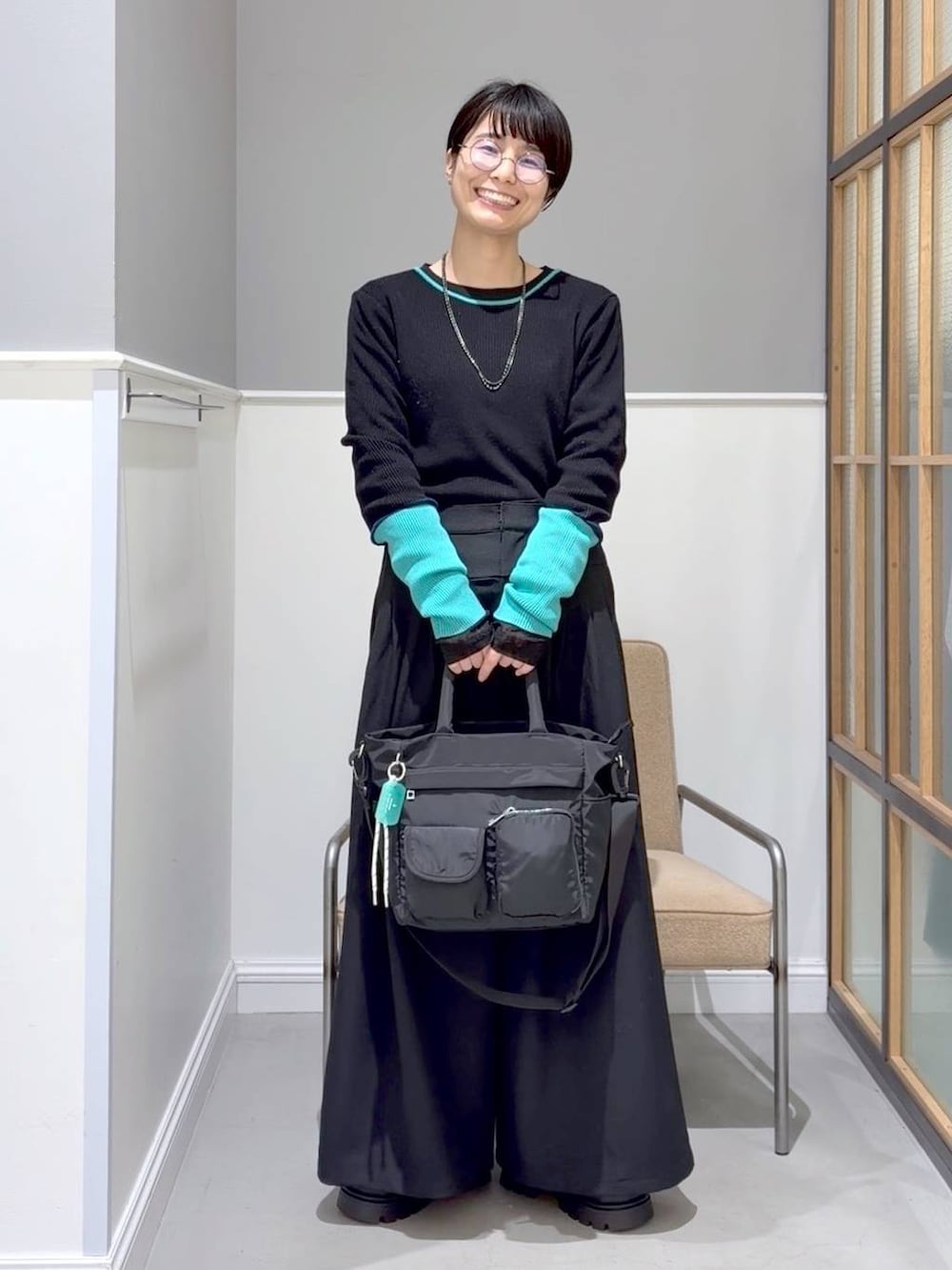 ブラック系のTシャツ/カットソー、ブラック系のトートバッグ、ブラック系のその他シューズを着用したレディースの冬コーディネートの4枚目の写真