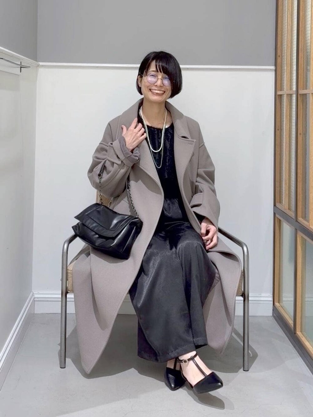 ブラウン系のステンカラーコート、ブラック系のTシャツ/カットソー、ブラック系のその他パンツを着用したレディースの冬コーディネートの2枚目の写真