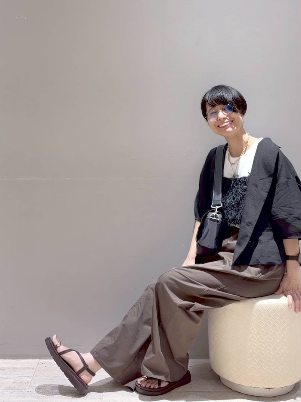 ブラウン系のその他パンツ、ブラック系のその他トップス、ブラック系のショルダーバッグを着用したレディースの夏コーディネートの2枚目の写真