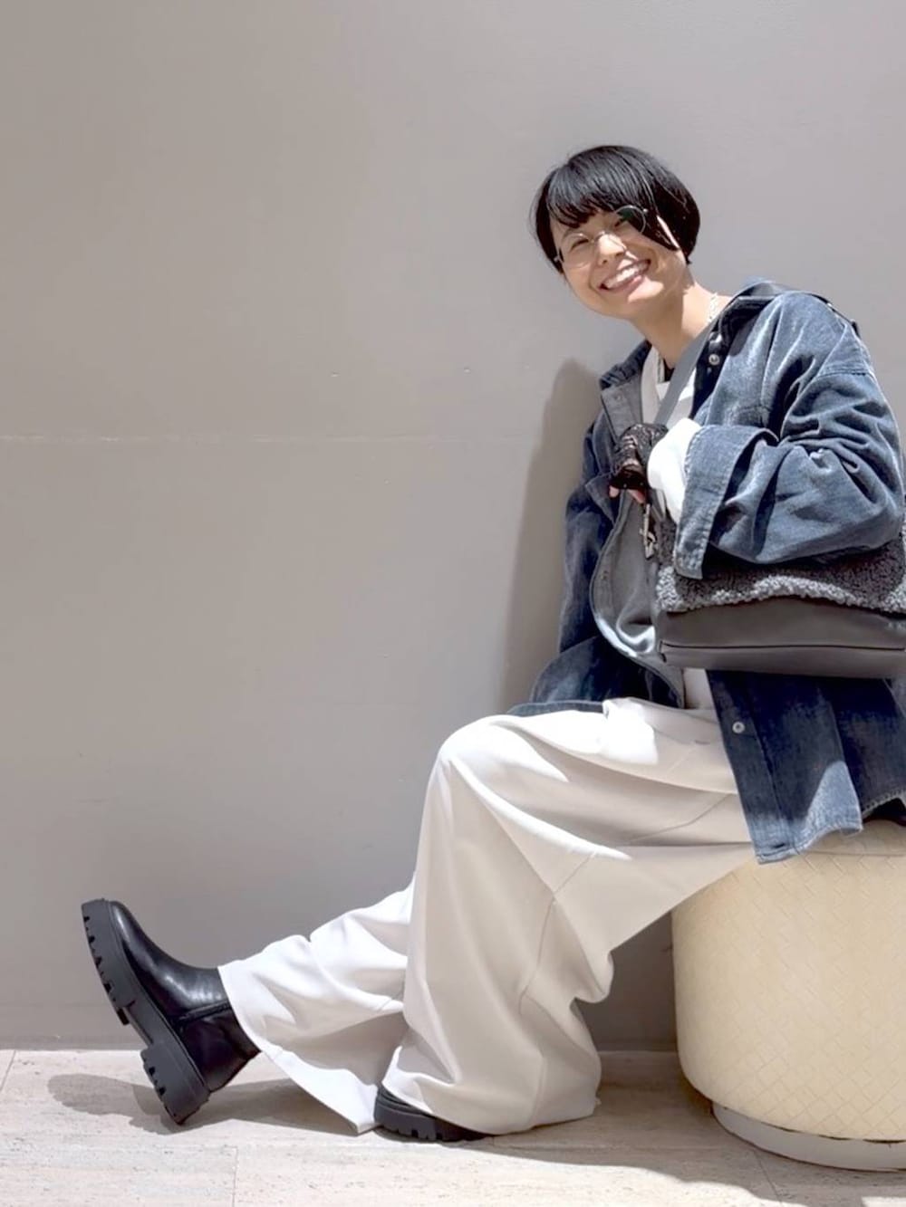 グレー系のショルダーバッグ、ホワイト系のその他パンツ、ブラック系のブーツを着用したレディースの秋コーディネートの2枚目の写真