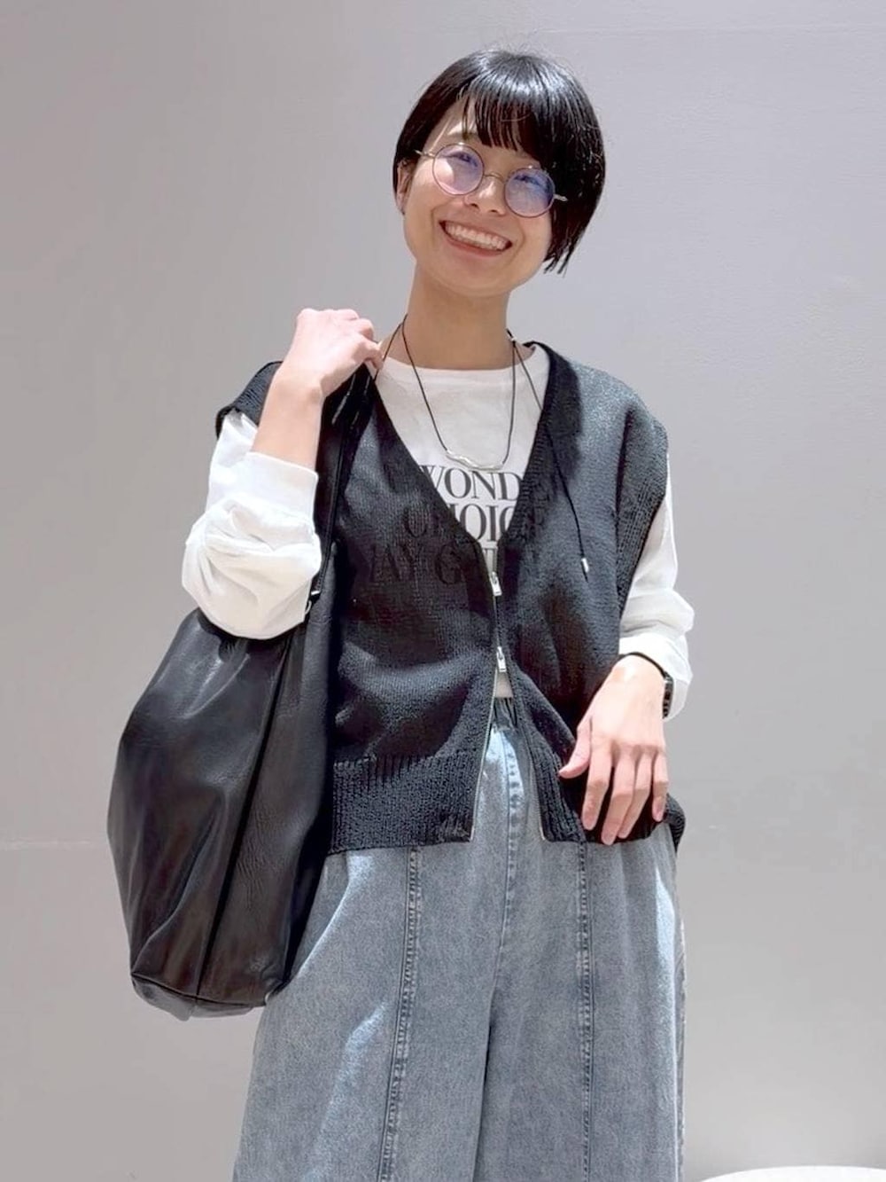 ブラック系のショルダーバッグ、ブラック系のパンプス、グレー系のベストを着用したレディースの春コーディネートの8枚目の写真