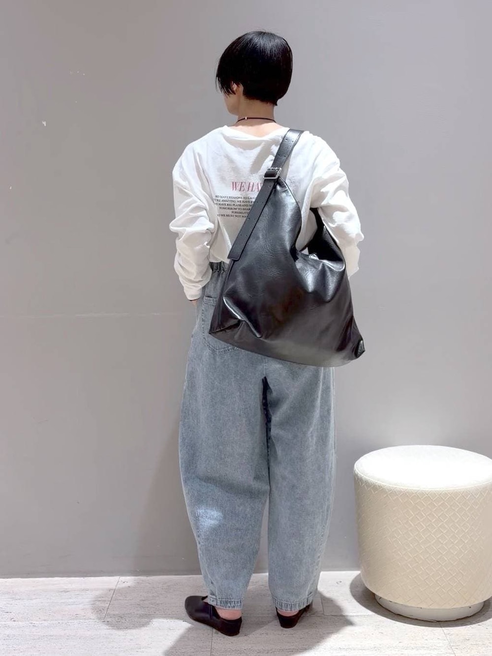 ブラック系のショルダーバッグ、ブラック系のパンプス、グレー系のベストを着用したレディースの春コーディネートの5枚目の写真