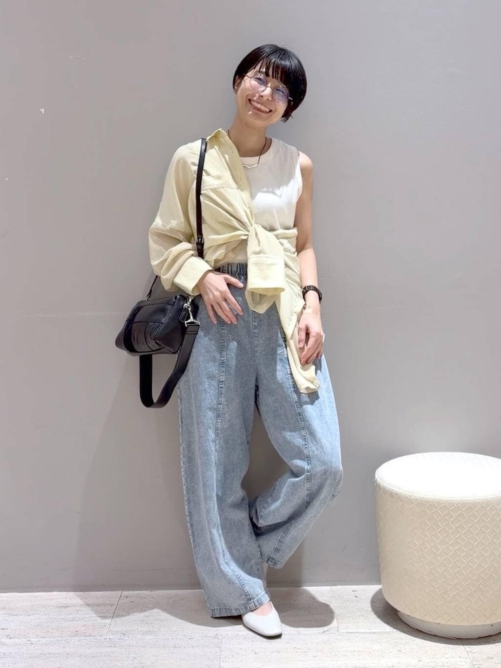 ホワイト系のパンプス、ホワイト系のタンクトップ、ブラック系のショルダーバッグを着用したレディースの春コーディネートの8枚目の写真